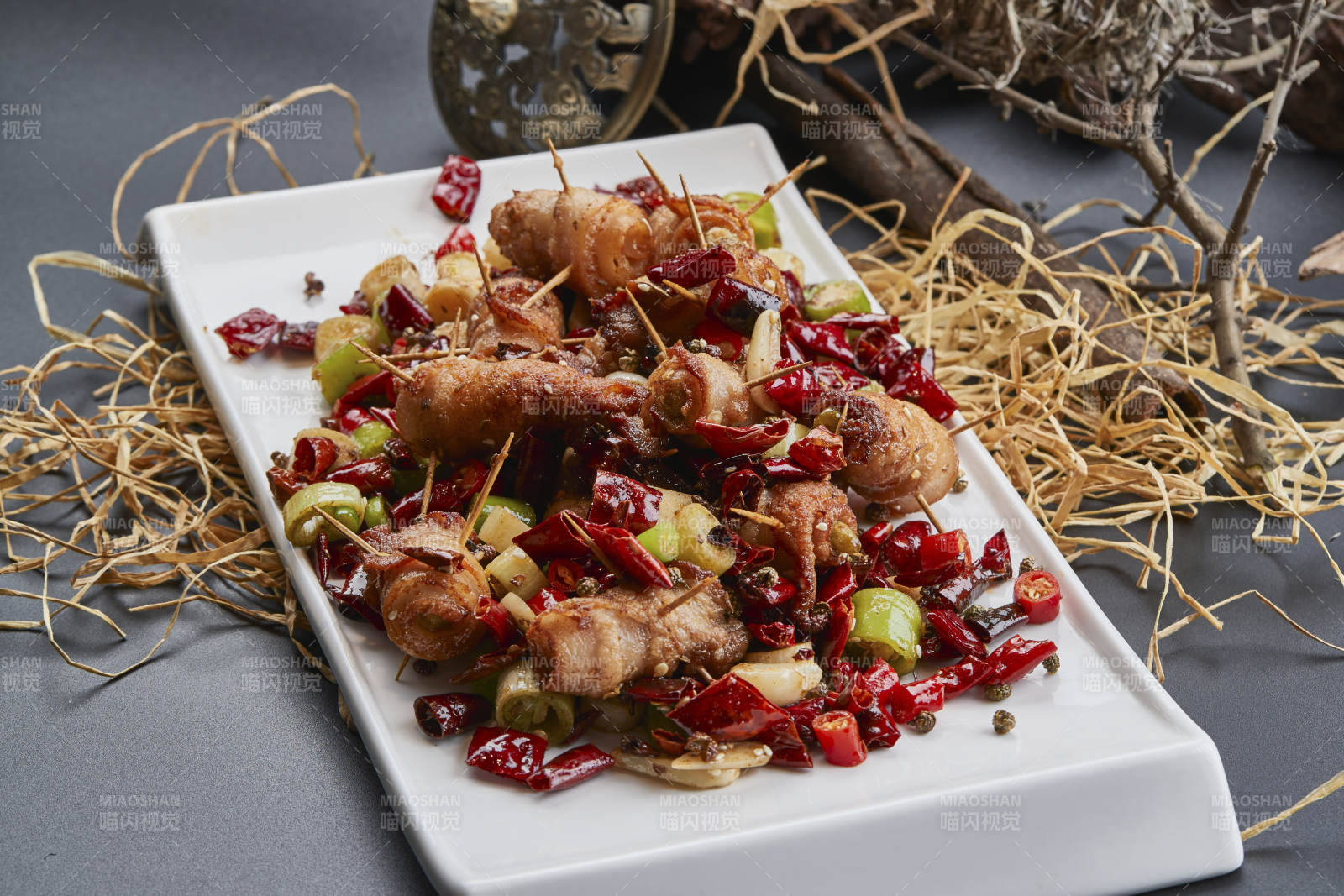 白瓷盘装的辣子油炸五花肉山椒卷图片