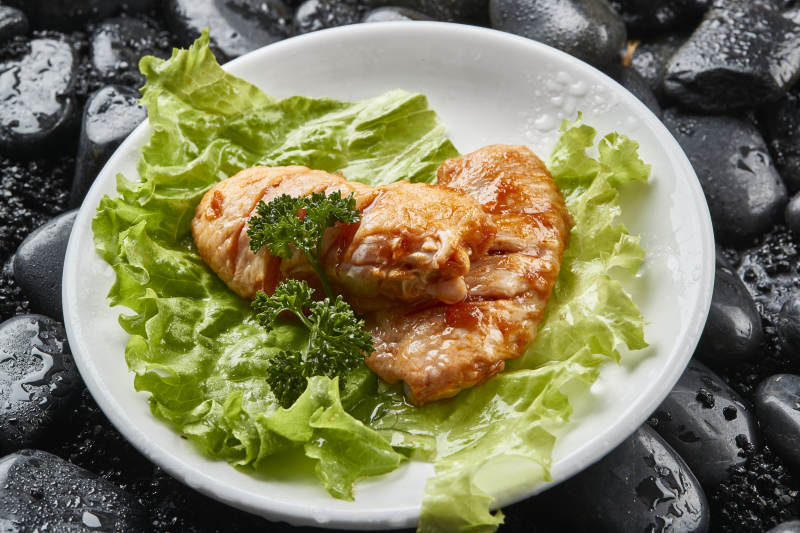 白色瓷盘装的烤肉食材生腌渍鸡翅图片