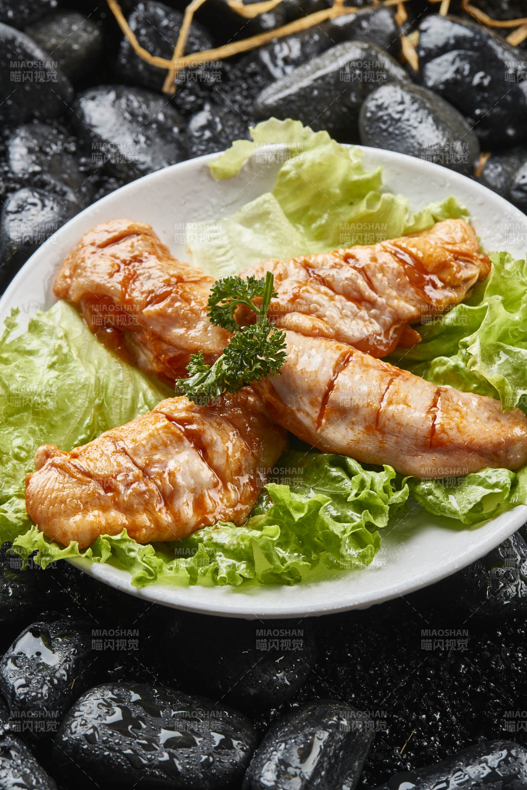 白色瓷盘装的烤肉食材生腌渍鸡翅图片