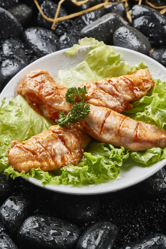 白色瓷盘装的烤肉食材生腌渍鸡翅图片