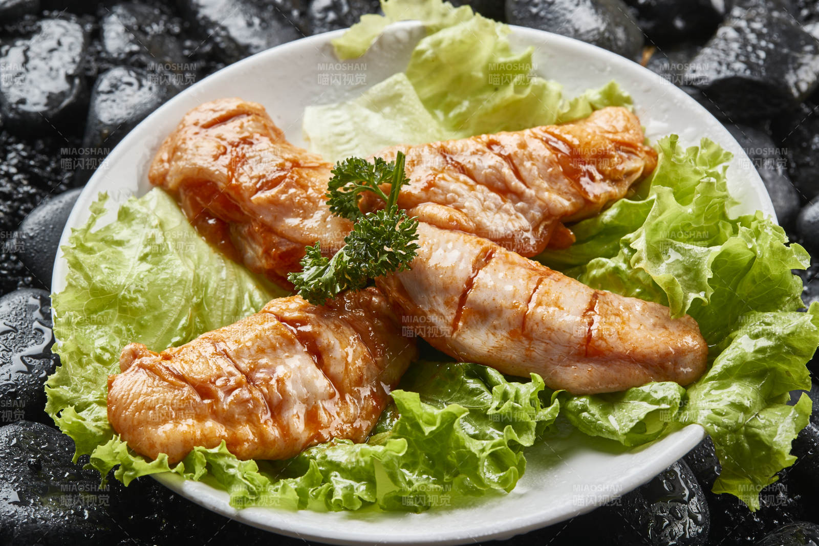 白色瓷盘装的烤肉食材生腌渍鸡翅图片