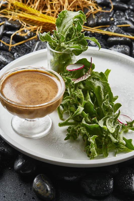 白色瓷盘装的凯撒酱配新鲜穿心莲图片