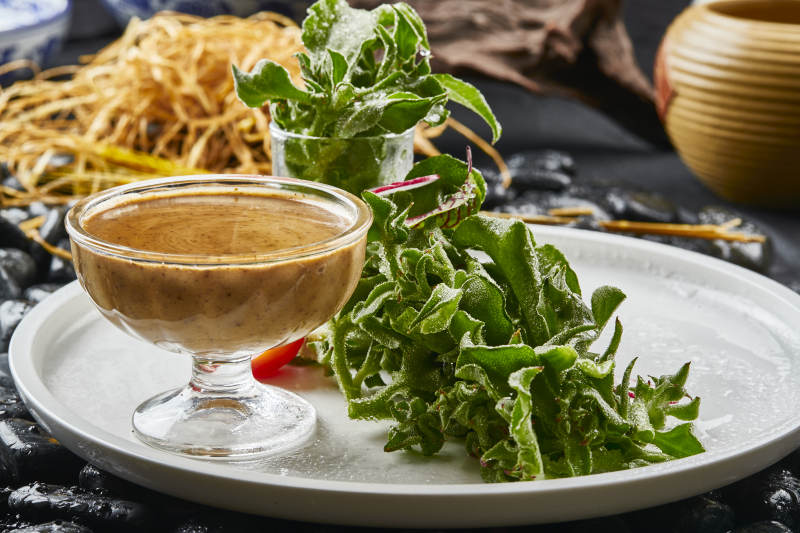 白色瓷盘装的凯撒酱配新鲜穿心莲图片