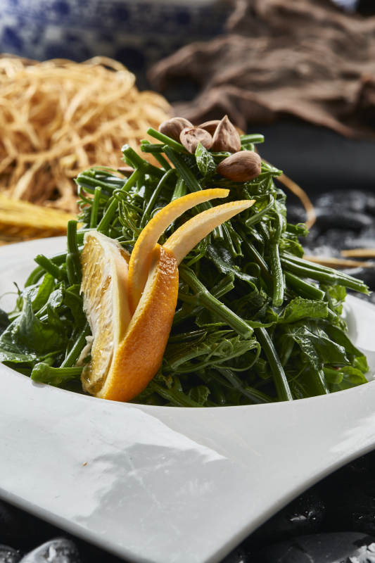 白色瓷盘装的鲜橙杏仁儿拌蕨菜图片