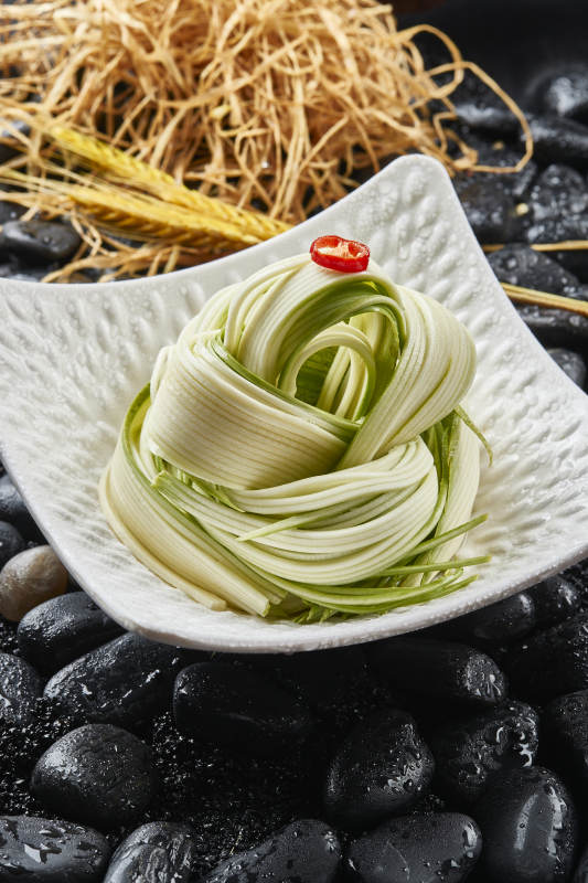 白色瓷盘装的浇汁凉拌西芹丝图片