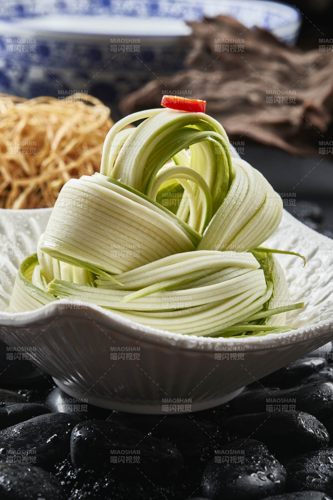 白色瓷盘装的浇汁凉拌西芹丝图片