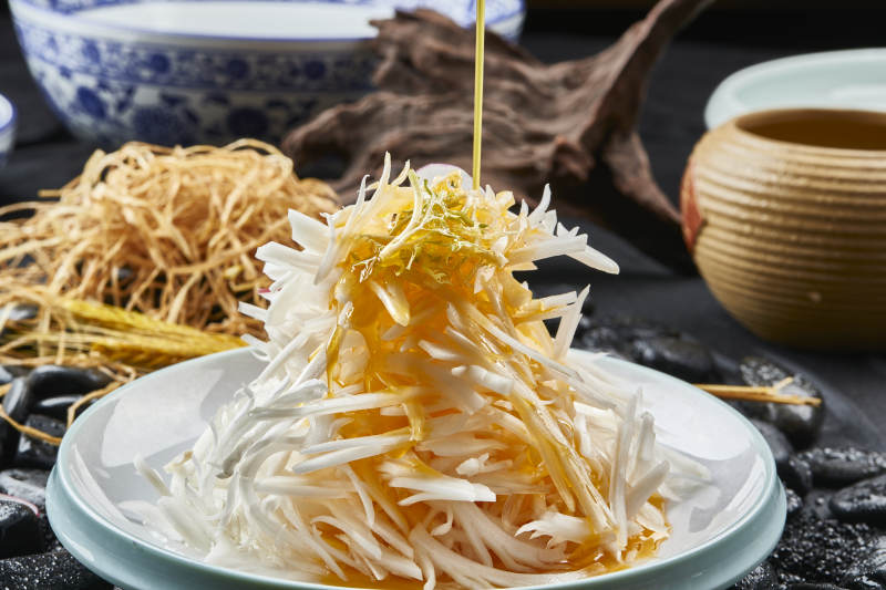 白色瓷盘装的浇汁马牙山药丝图片