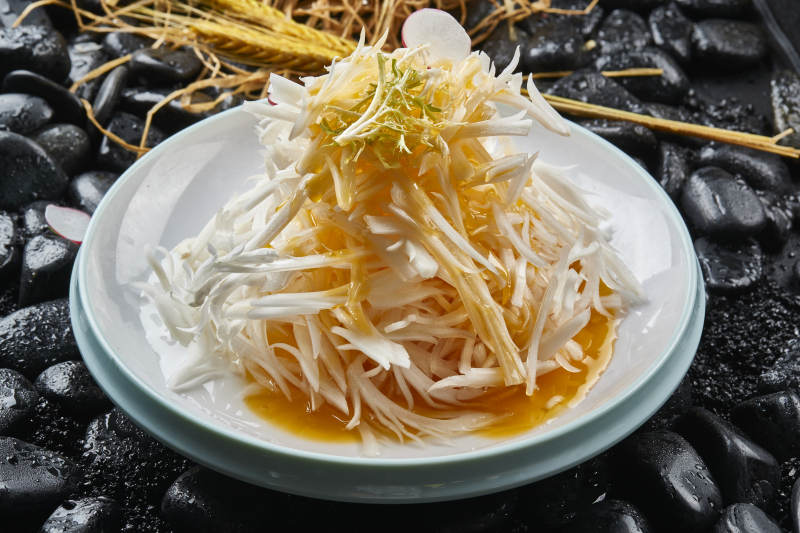 白色瓷盘装的浇汁马牙山药丝图片