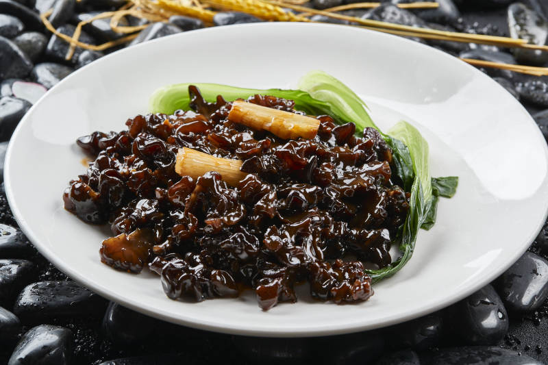 白色瓷盘装的葱烧木耳黑皮参图片