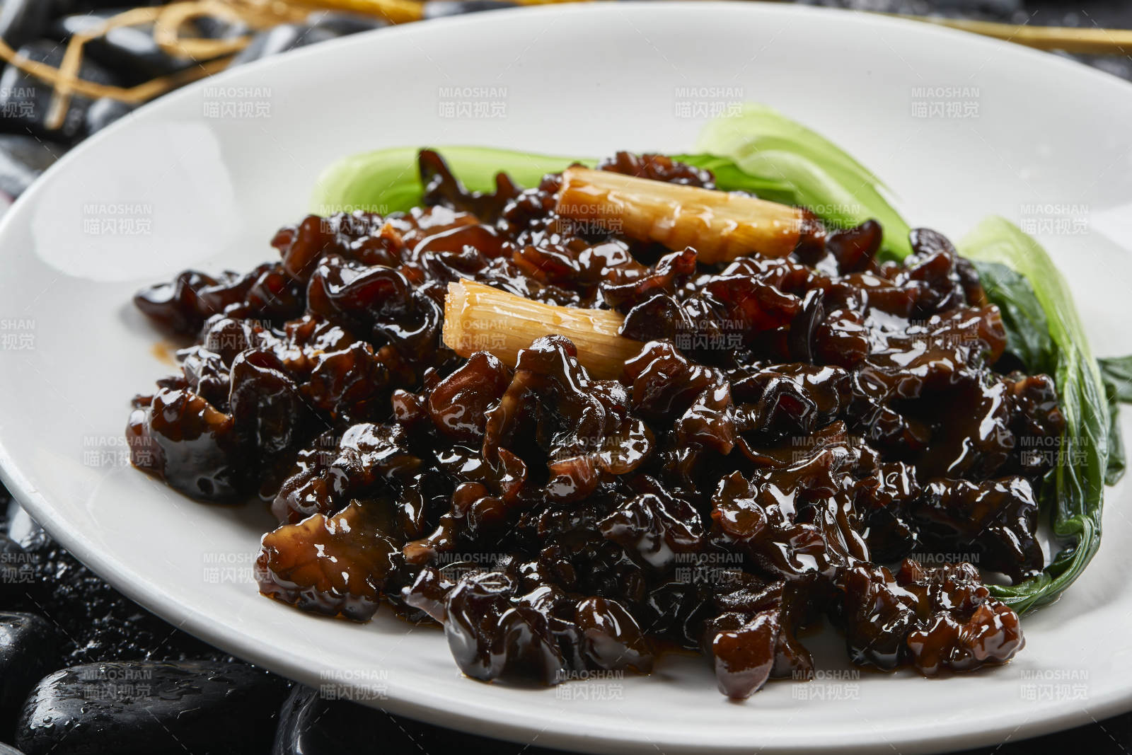 白色瓷盘装的葱烧木耳黑皮参图片