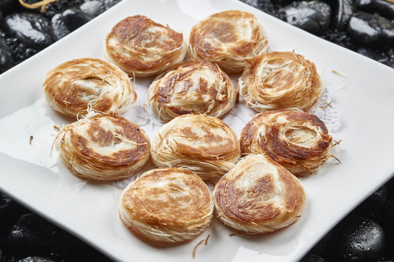 白色瓷盘装的一窝丝豆沙馅烧饼图片
