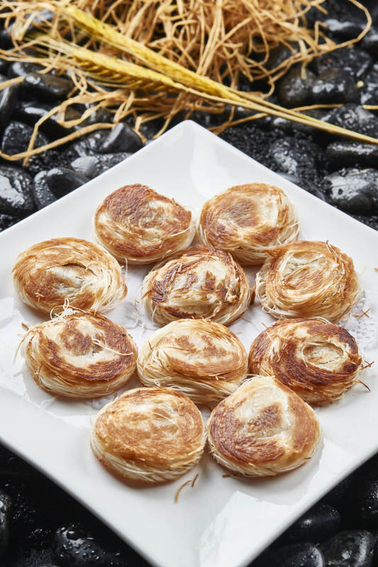 白色瓷盘装的一窝丝豆沙馅烧饼图片