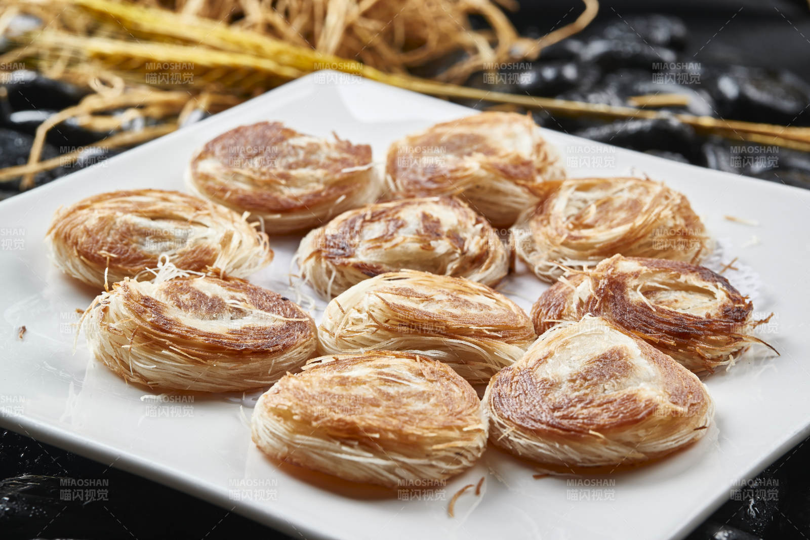 白色瓷盘装的一窝丝豆沙馅烧饼图片