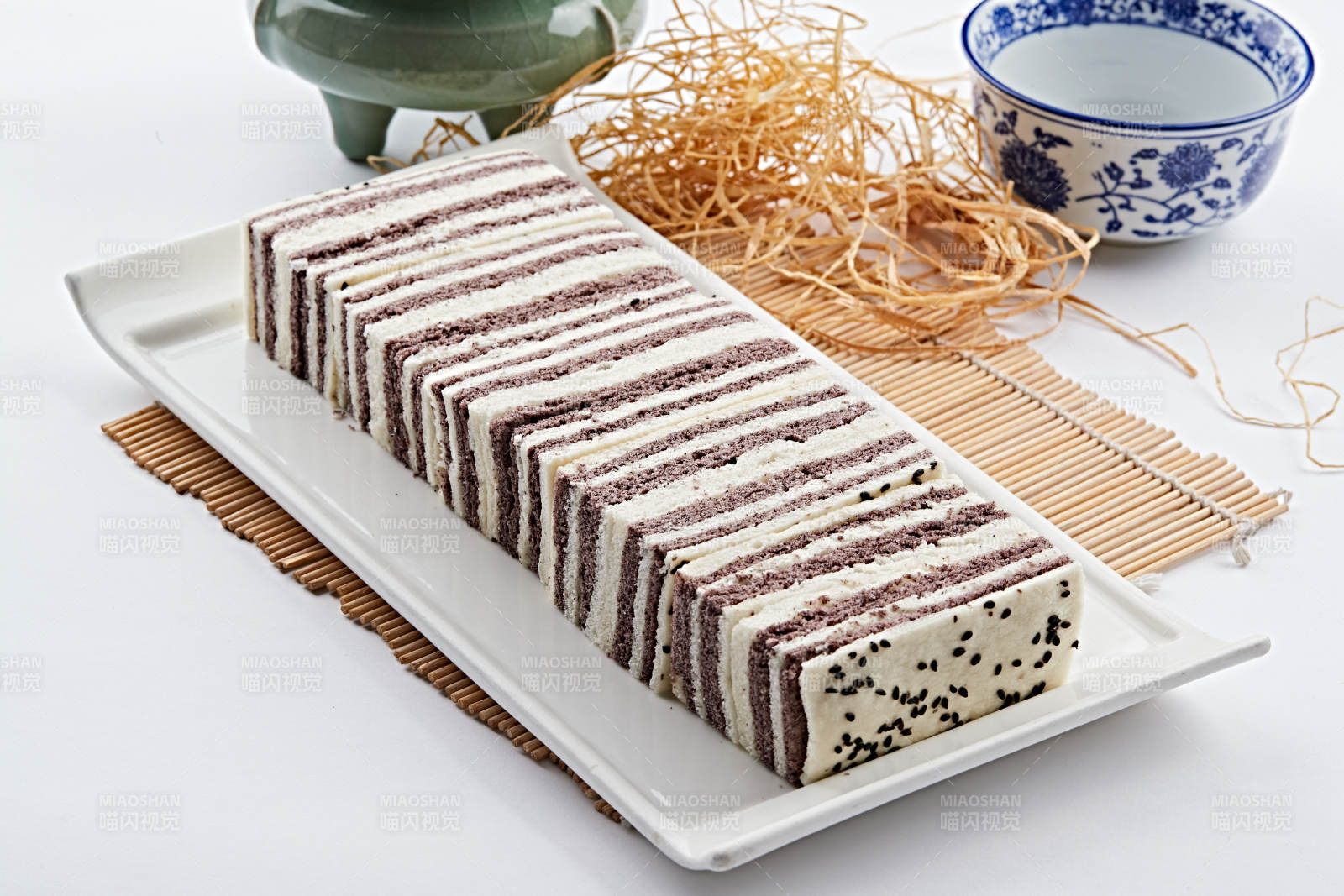 长方形白瓷盘装的双色发糕图片