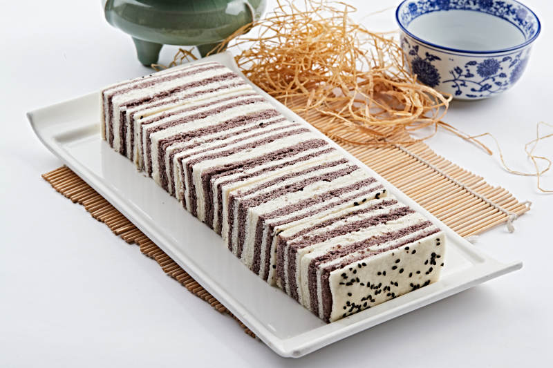 长方形白瓷盘装的双色发糕图片