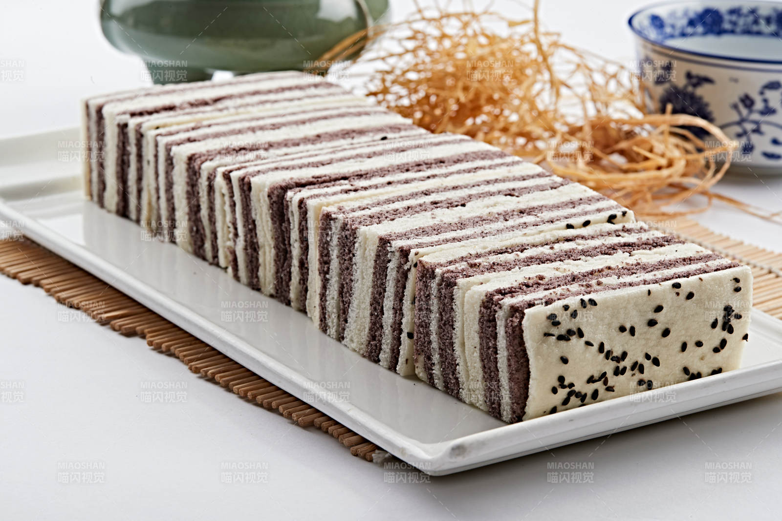 长方形白瓷盘装的双色发糕图片