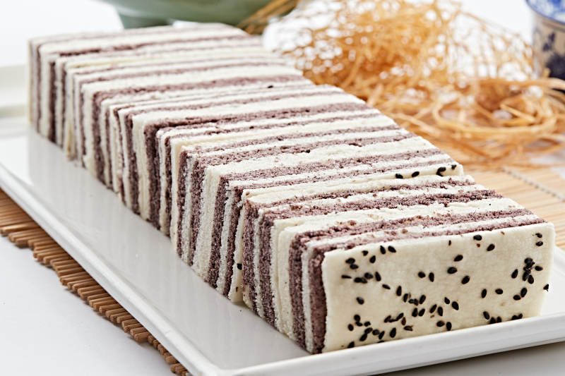 长方形白瓷盘装的双色发糕图片