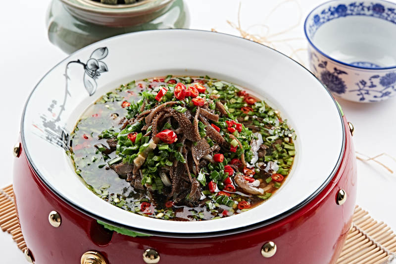 红木底托上的白瓷盘装的葱香毛肚图片