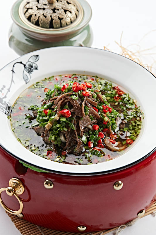 红木底托上的白瓷盘装的葱香毛肚图片