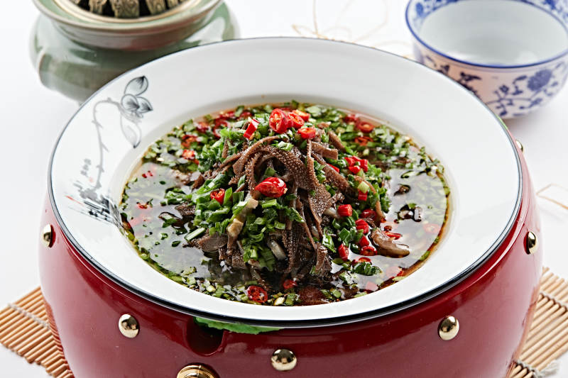 红木底托上的白瓷盘装的葱香毛肚图片