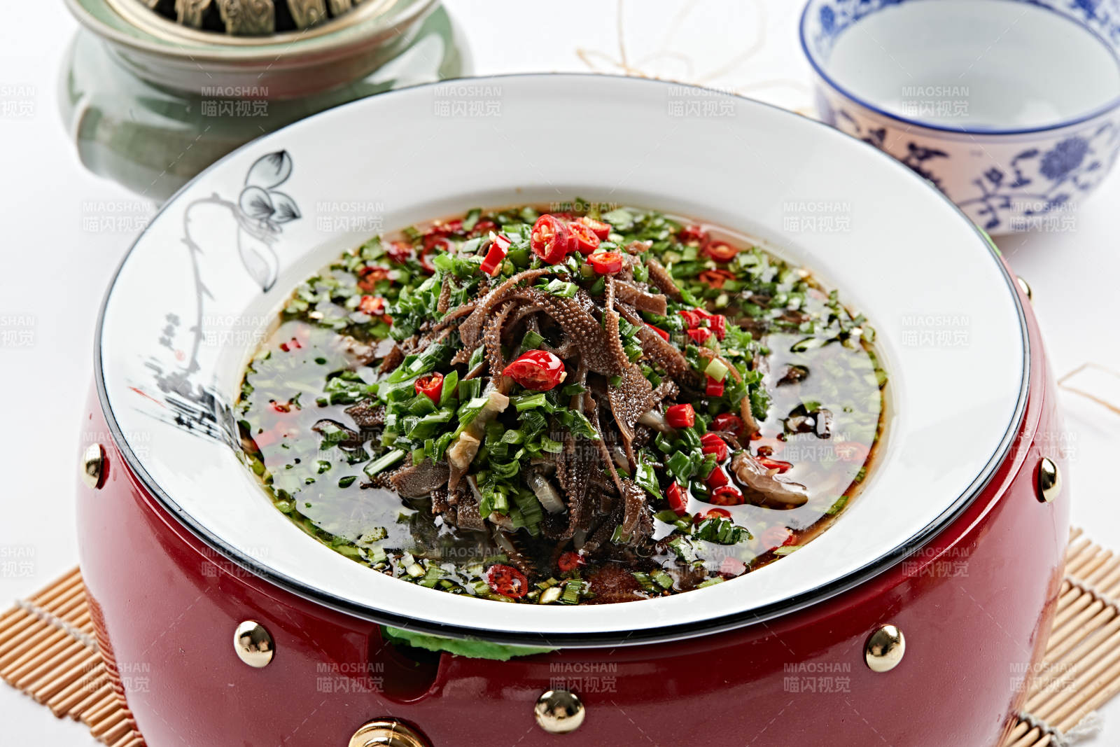 红木底托上的白瓷盘装的葱香毛肚图片