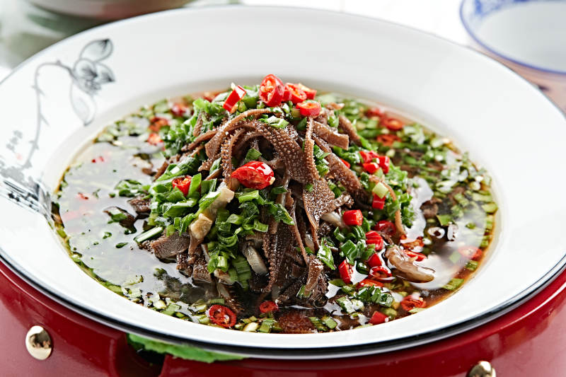 红木底托上的白瓷盘装的葱香毛肚图片