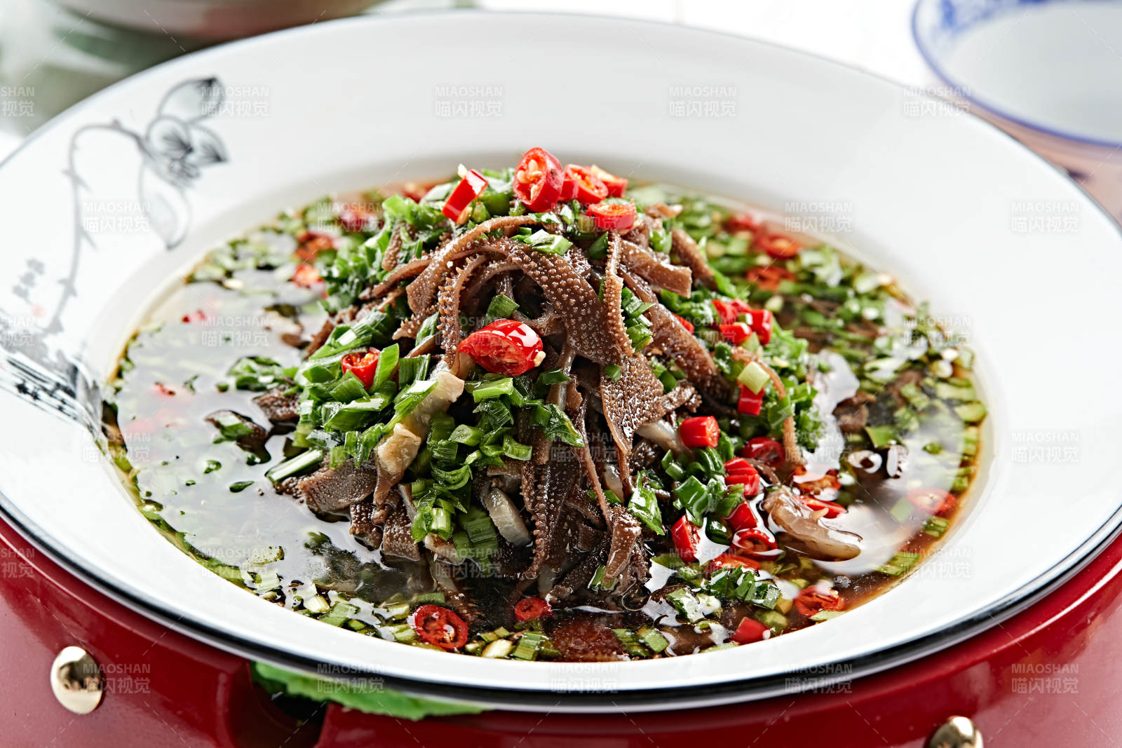 红木底托上的白瓷盘装的葱香毛肚图片