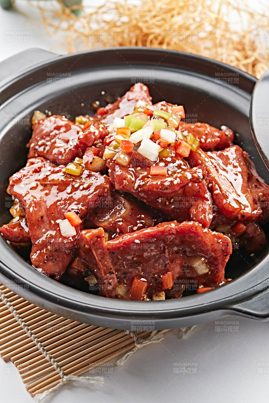 黑色砂锅装的黑胡椒烧牛仔骨图片