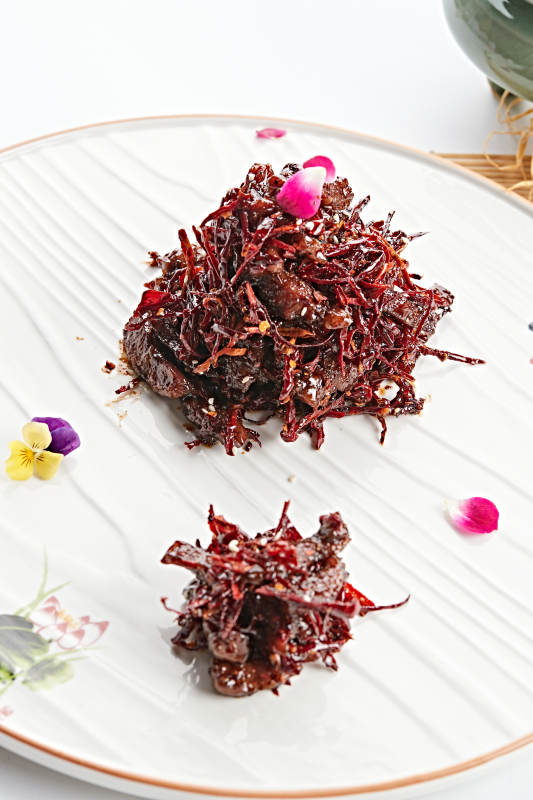 白色花纹瓷盘装的火边子牛肉图片