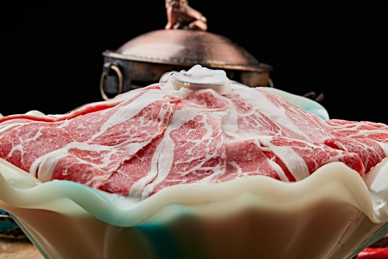 干冰缭绕的背景上摆放的高级雪花肥牛切片图片