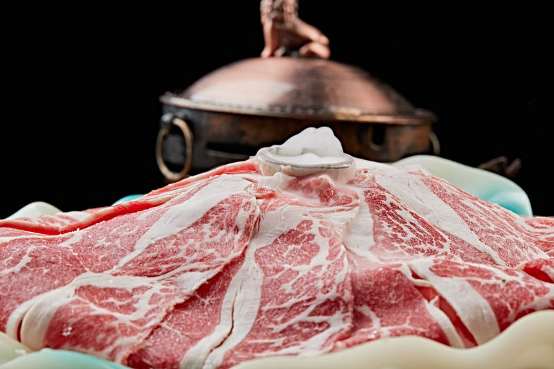 干冰缭绕的背景上摆放的高级雪花肥牛切片图片