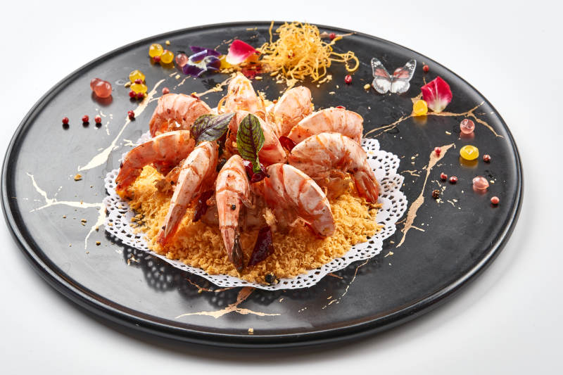 黑色瓷盘装的避风塘炸虾图片