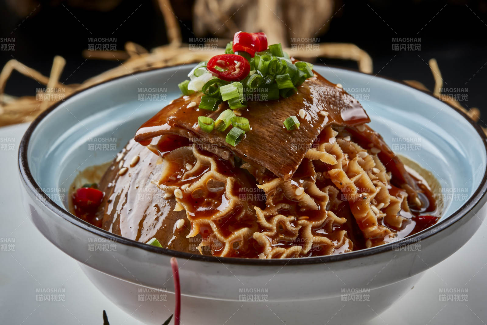 黑色背景上的瓷餐具装的川味夫妻肺片图片