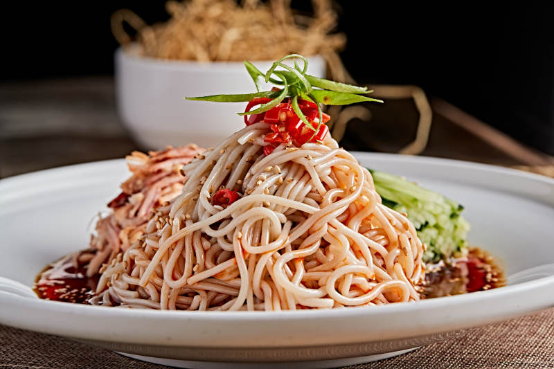 白色瓷盘装红油鸡丝冷面图片