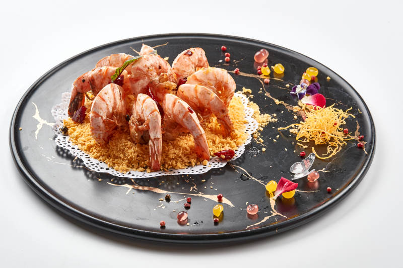 黑色瓷盘装的避风塘炸虾图片