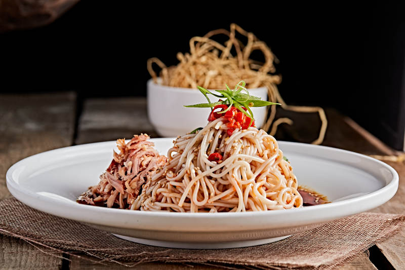 白色瓷盘装红油鸡丝冷面图片