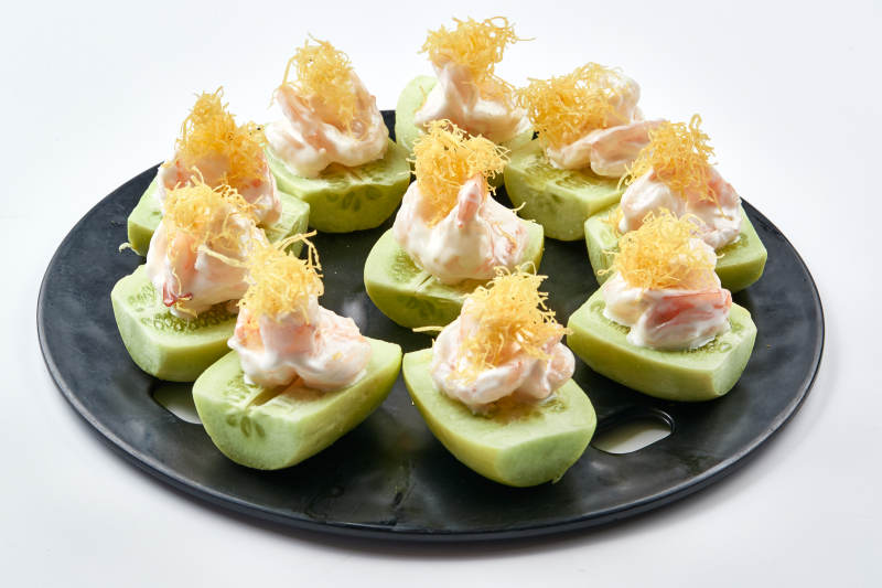 黑色瓷盘装的沙拉大虾仁图片