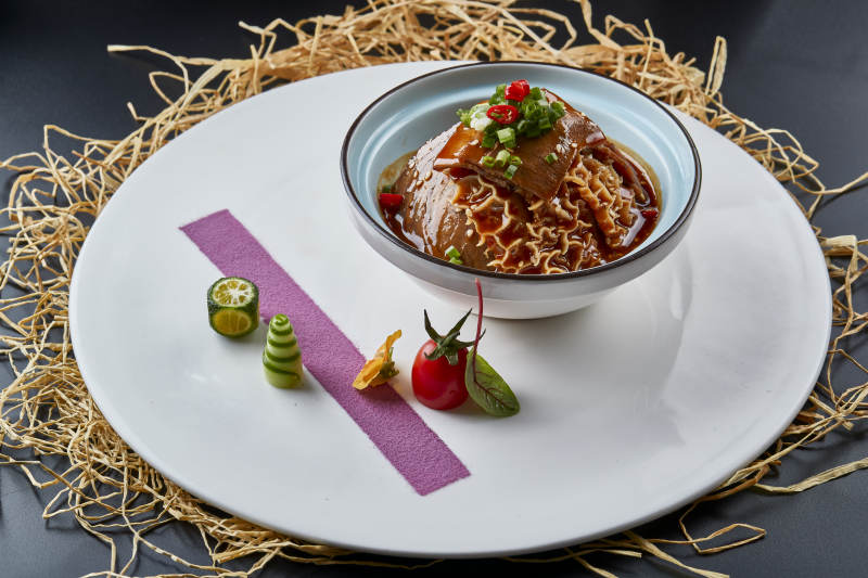 黑色背景上的瓷餐具装的川味夫妻肺片图片