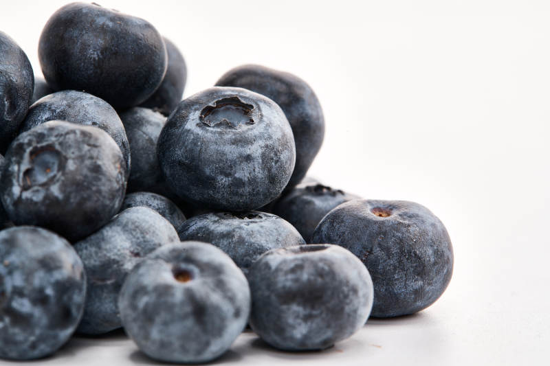白色背景上摆放的水润新鲜蓝莓果图片