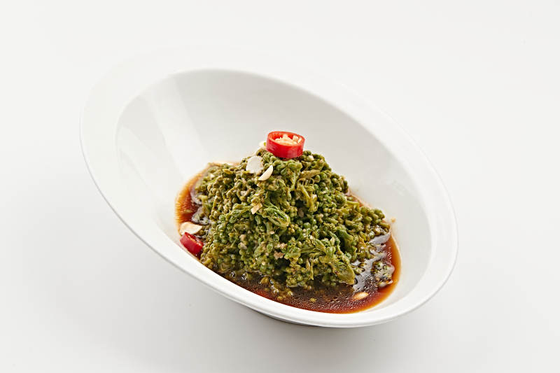 白色瓷盘装的醋腌凉拌木瓜花图片