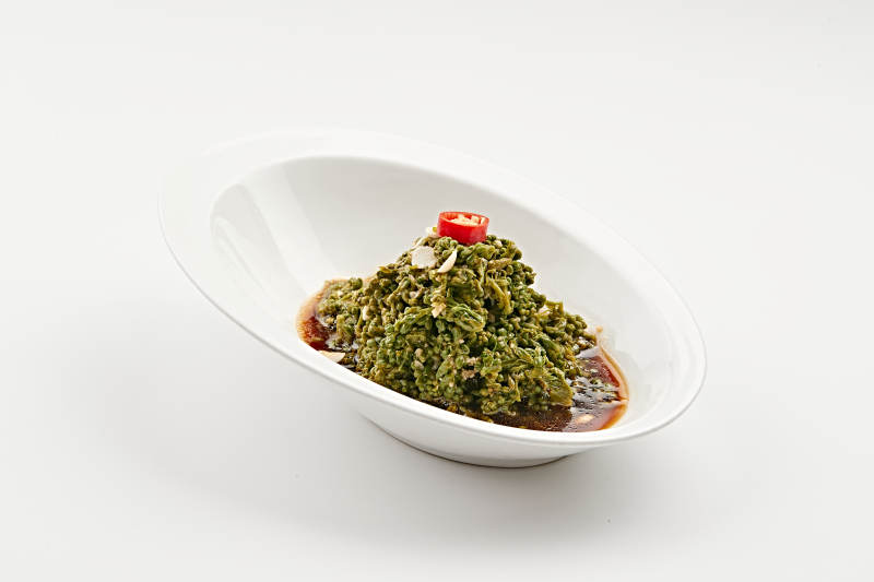 白色瓷盘装的醋腌凉拌木瓜花图片