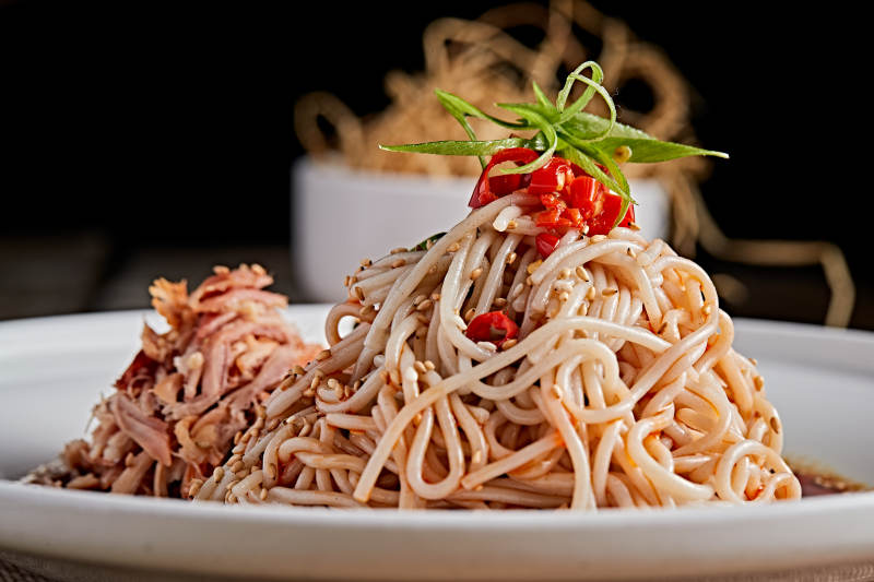 白色瓷盘装红油鸡丝冷面图片