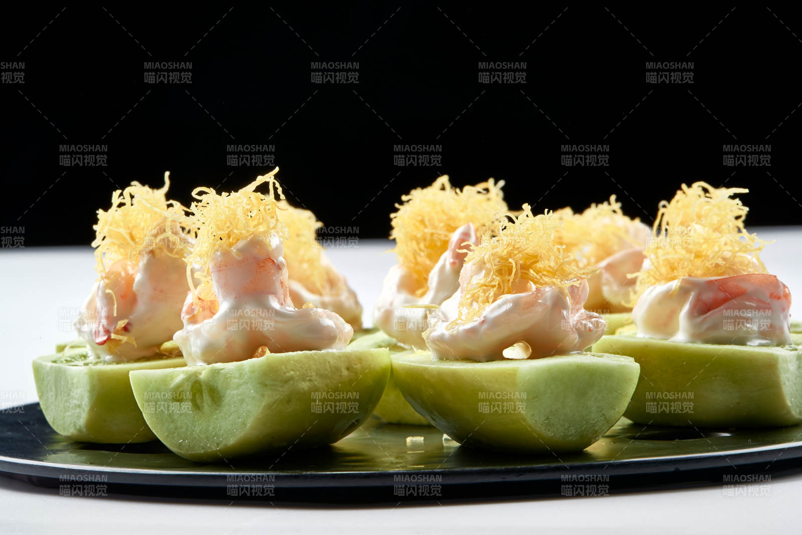 黑色瓷盘装的沙拉大虾仁图片