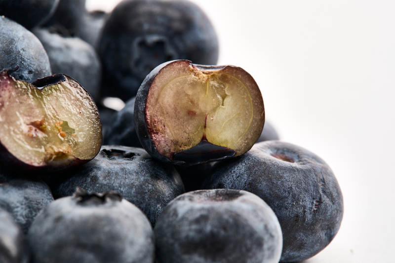 白色背景上摆放的水润新鲜蓝莓果图片