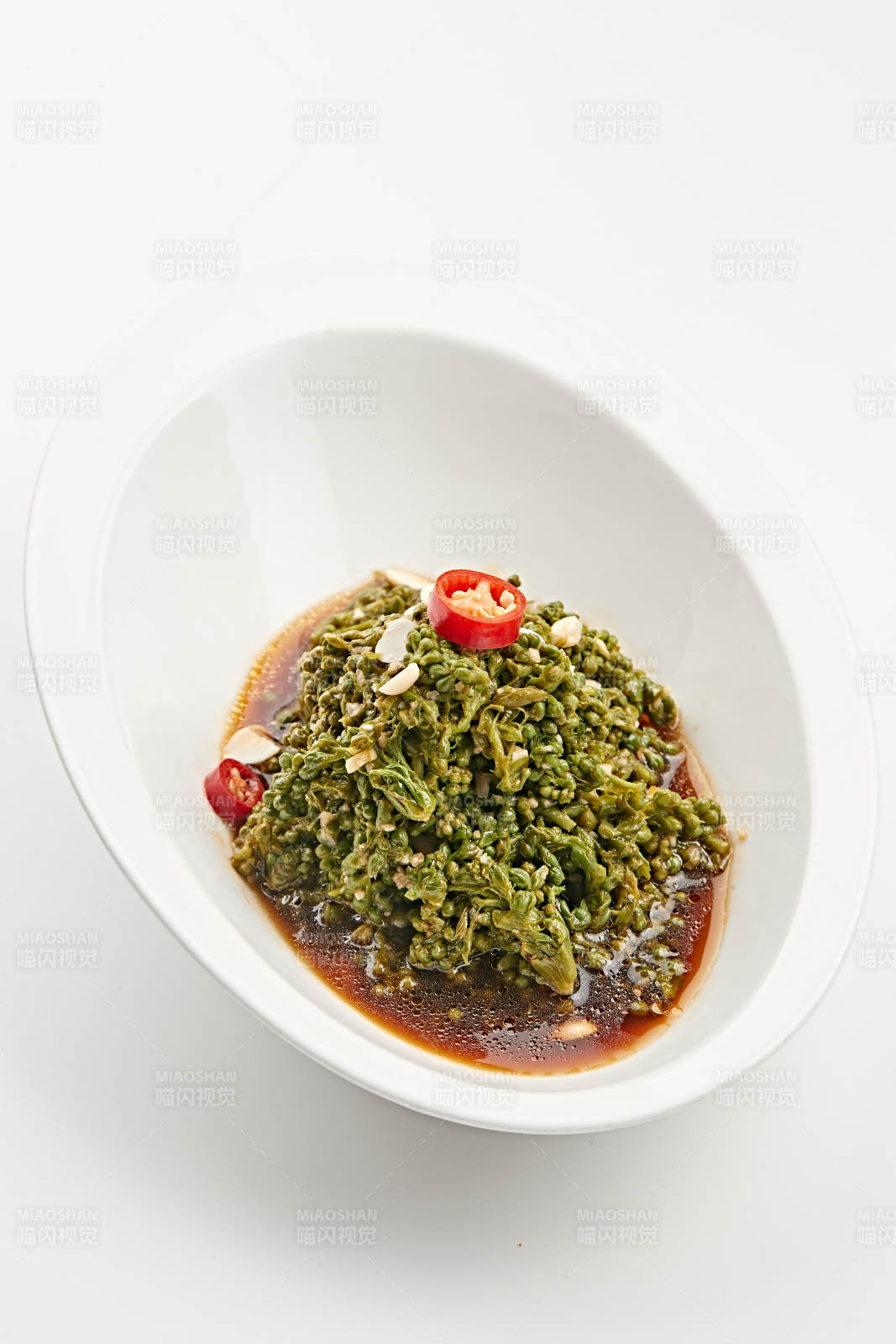 白色瓷盘装的醋腌凉拌木瓜花图片