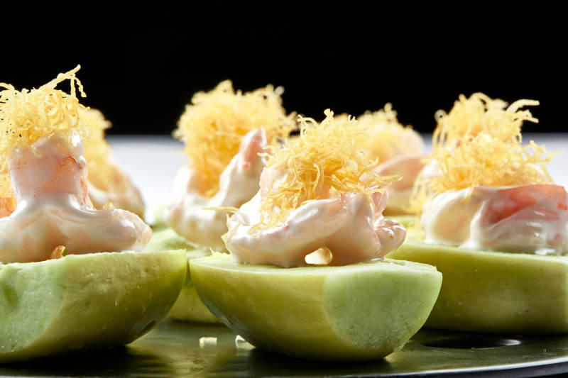 黑色瓷盘装的沙拉大虾仁图片