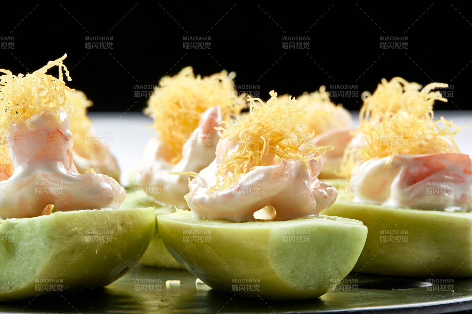 黑色瓷盘装的沙拉大虾仁图片