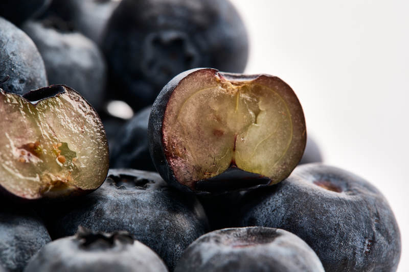 白色背景上摆放的水润新鲜蓝莓果图片