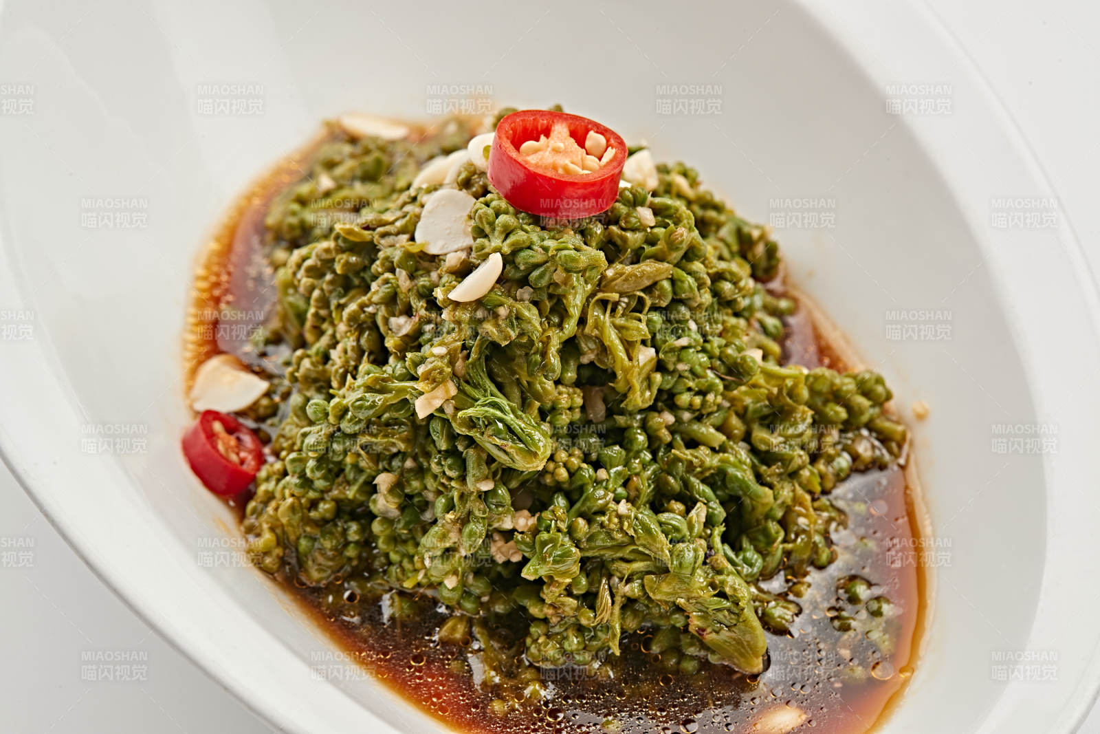 白色瓷盘装的醋腌凉拌木瓜花图片