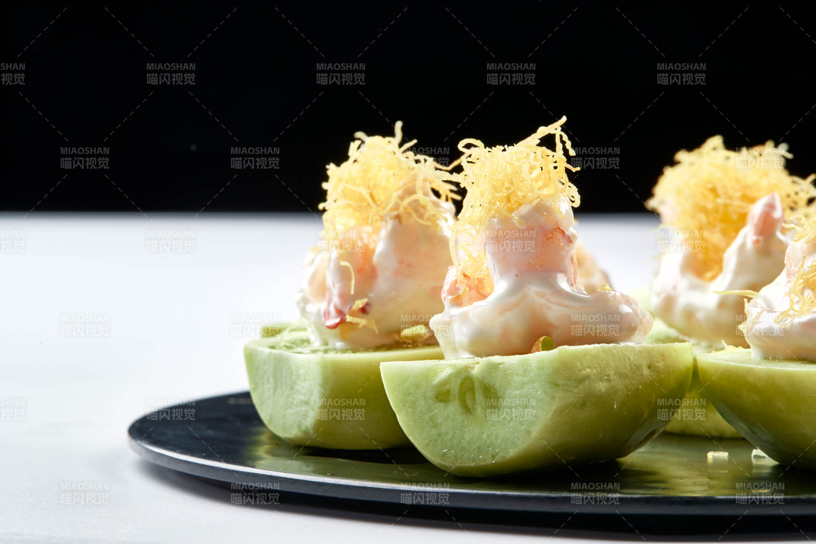 黑色瓷盘装的沙拉大虾仁图片